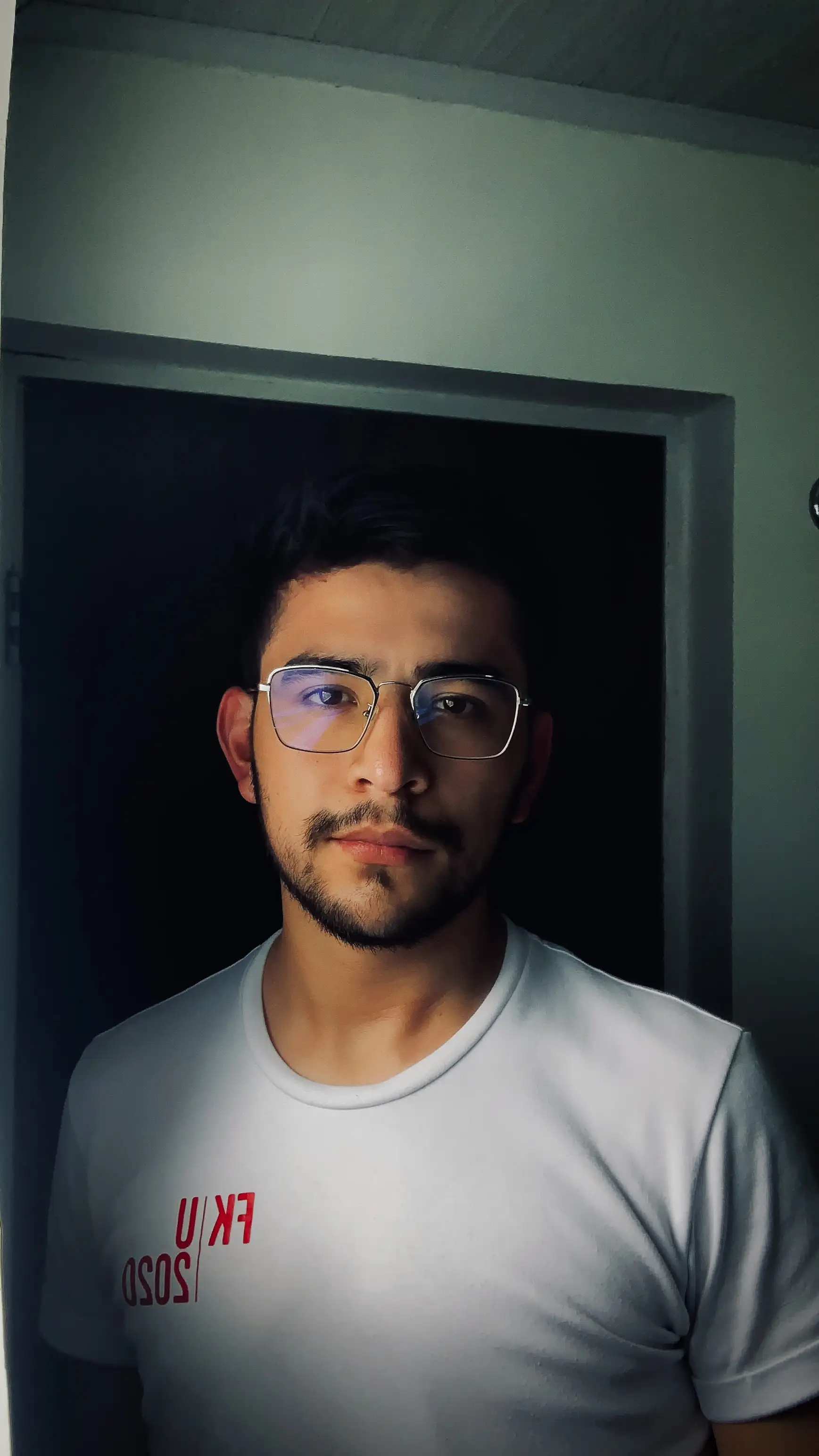 Cesar Cruz in a white t-shirt and glasses